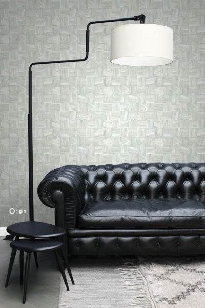 Wohnzimmer mit Ledersofa, Stehlampe und gemusterter Tapete