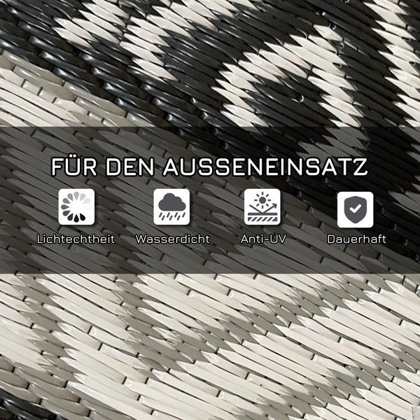 Runder Outdoor-Teppich mit grafischem Muster in Grau und Weiß auf einer Terrasse.