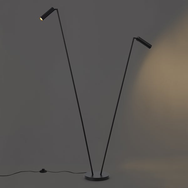 Moderne schwarze Stehleuchte mit zwei dünnen, verstellbaren Armen, zylindrischen Lichtköpfen, rundem Standfuß und Fußschalter.