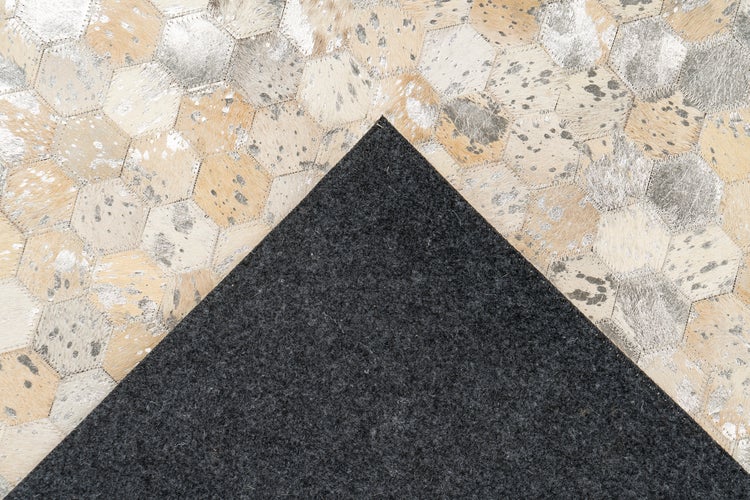 Kuhfell-Teppich im Sechseck-Patchwork-Design mit metallischen Akzenten und dunkler Filzunterseite.