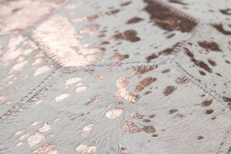 Detailansicht eines Patchwork Teppichs aus Leder mit metallischer Prägung und sichtbaren Nähten.