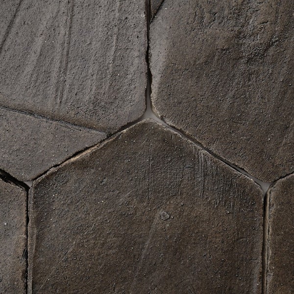 Strukturierte Polygonalplatten aus Naturstein mit unregelmäßiger Oberfläche und erkennbaren Fugen.