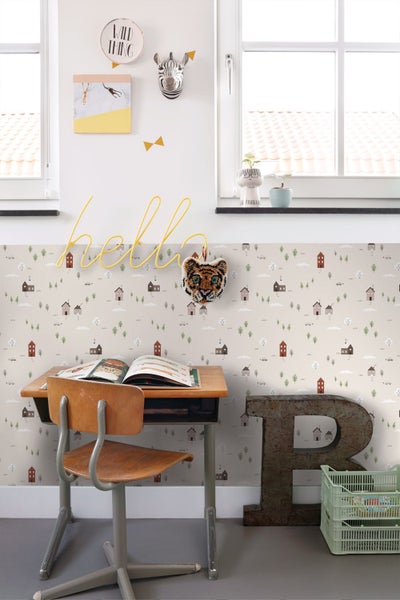Kinderzimmer mit Papiertapete mit Häuser- und Baummuster, Holzschreibtisch und Wandregal mit Spielzeugautos.