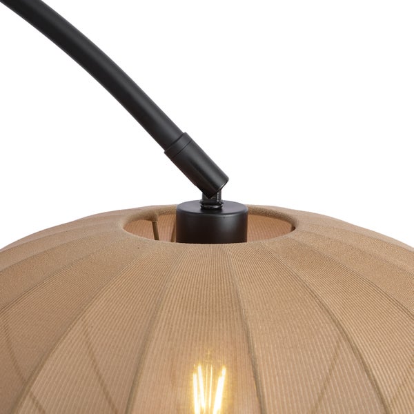 Nahaufnahme eines beigen Stoffschirms einer Lampe mit schwarzem Metallgestänge und leuchtendem Leuchtmittel.