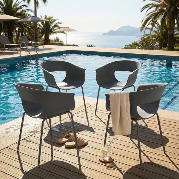 Vier moderne Gartenstühle in Schalenform mit Metallbeinen auf einer Holzterrasse an einem Swimmingpool vor einer Meerkulisse.