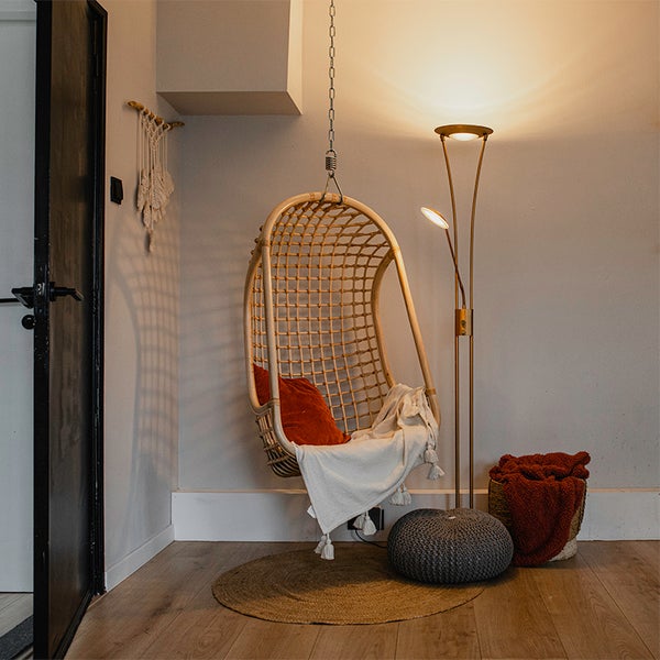 Wohnraum mit Hängekorbsessel, Stehlampe und Wohnaccessoires