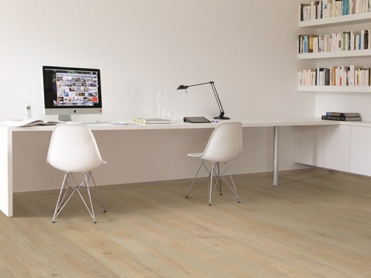 Helles Arbeitszimmer mit großem weißem Schreibtisch, zwei Designerstühlen und hochwertigem Bodenbelag in Holzoptik.