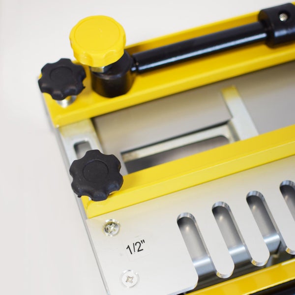 Detailansicht einer Zinkeneinrichtung mit Verstellknöpfen und einer Schablonenführung mit der Aufschrift ein halb Zoll.