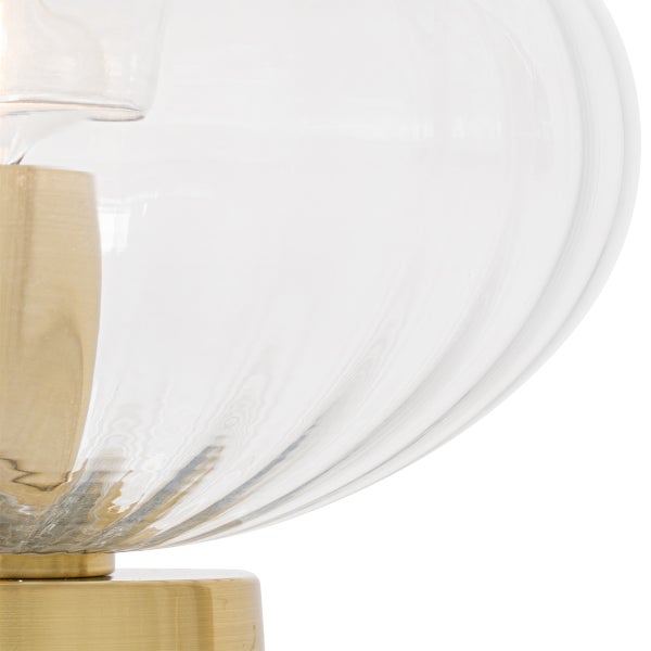 Detailaufnahme einer Tischleuchte mit einem Sockel aus Metall und einem Lampenschirm aus Glas