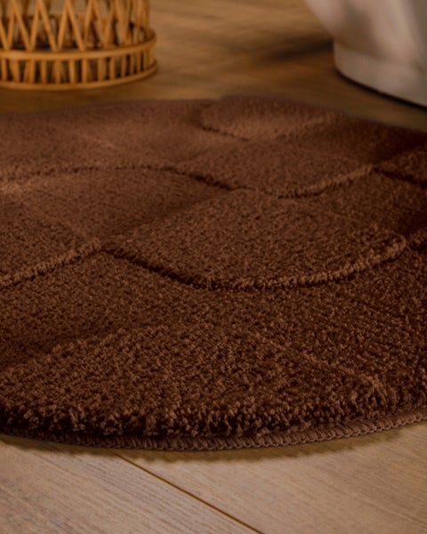 Braune aufgerollte Hochflor-Badematte mit weicher, strukturierter Oberfläche.