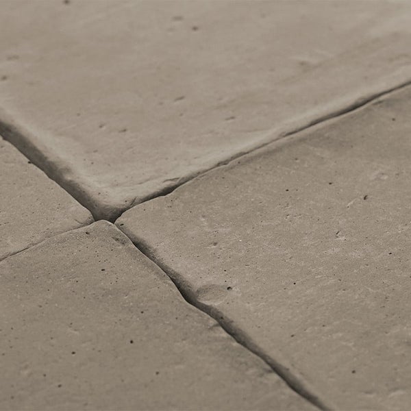 Nahaufnahme von quadratischen Betonpflastersteinen mit rauer Oberflächenstruktur und deutlichen Fugen