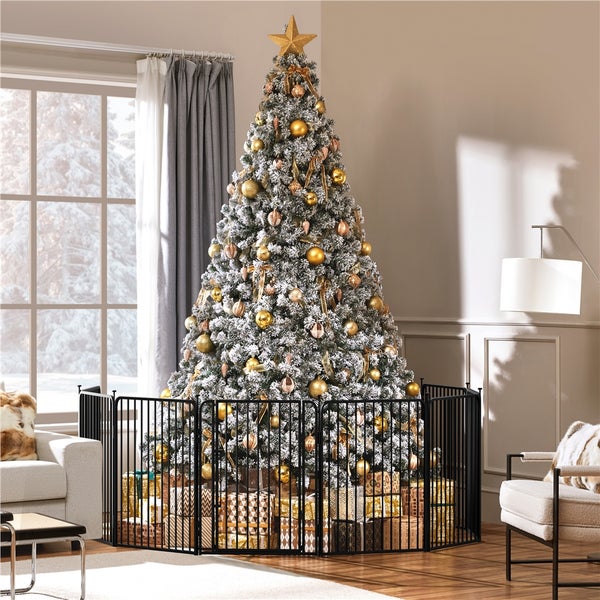 Festlich geschmückter Weihnachtsbaum mit goldenen Kugeln und Baumspitze, umgeben von einem schwarzen Schutzgitter im Wohnzimmer.