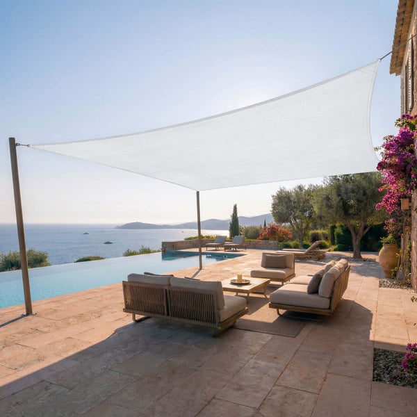 Großes Sonnensegel über einer hellen Terrasse mit Pool, modernen Loungemöbeln und weitem Meerblick.