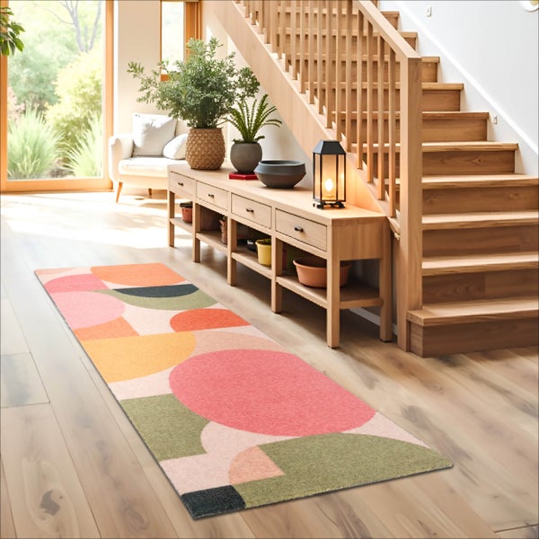 Moderner Flur mit einem langen Läufer-Teppich mit abstraktem geometrischem Muster auf Holzfußboden neben einer Treppe und einem Sideboard.
