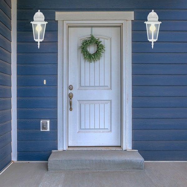 Szene einer Haustür mit Außenleuchten und Türkranz