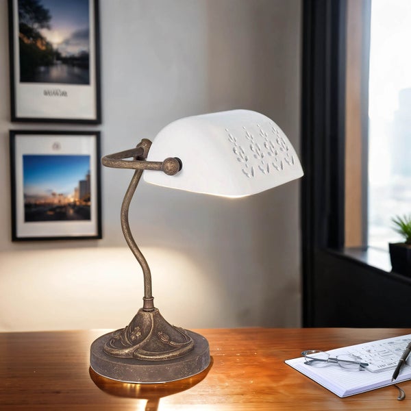 Tischleuchte mit floralen Ausschnitten auf einem Schreibtisch