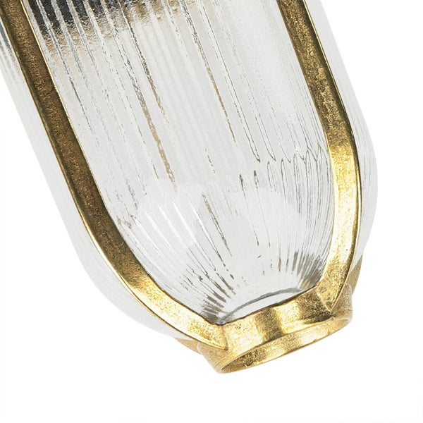 Nahaufnahme einer geriffelten Glaslampe mit goldfarbenen Akzenten