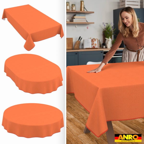 Orangene Tischdecke in verschiedenen Formen in einer hellen Küche, eine Frau glättet den Stoff auf dem Tisch, ANRO Logo, deutsche Herstellung.