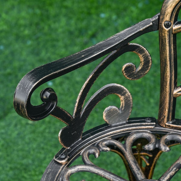 Detailaufnahme der geschwungenen Armlehne eines Gartenstuhls aus Metall mit antikem Design und Ornamenten.