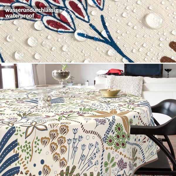 Runde Tischdecke mit buntem botanischem Muster in einem hellen Wohnzimmer, Detailansicht zeigt wasserabweisende Oberfläche mit Wassertropfen.