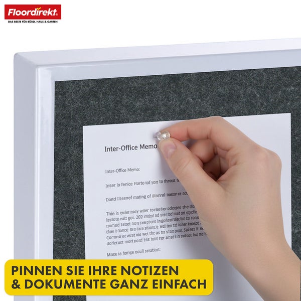 Person steckt Notiz mit Reißzwecke an Pinnwand