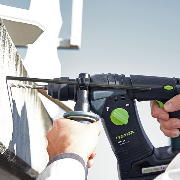 Mann bohrt mit einem Festool Bohrhammer ein Loch in eine Wand.