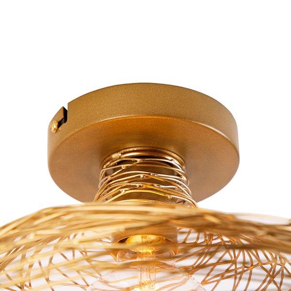 Nahaufnahme einer goldenen Deckenleuchte mit einem geometrischen Design