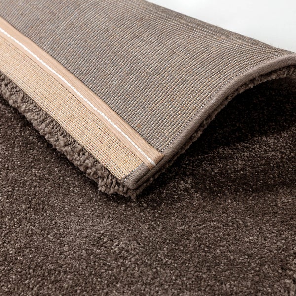Nahaufnahme eines Hochflor-Teppichs mit gewebter Rückseite und verstärktem Rand.