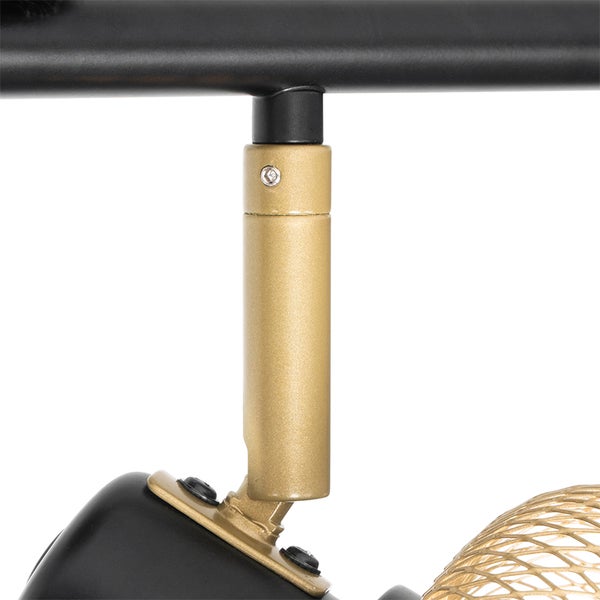 Detailaufnahme einer Deckenleuchte mit schwarzer Stange und goldenem Lampenarm