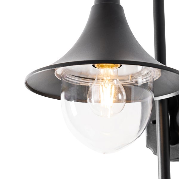 Schwarze Außenwandleuchte mit glockenförmigem Schirm, klarem Glaskolben und leuchtendem Filament-Leuchtmittel.