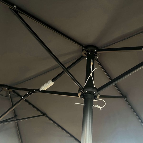 Detailansicht der Unterseite eines Gartenschirms mit schwarzem Gestell und Stoff