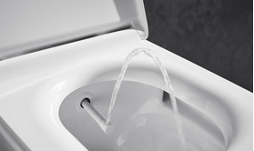 Nahaufnahme eines Toilettensitzes mit Bidetfunktion, bei dem ein Wasserstrahl aus einer Düse kommt.