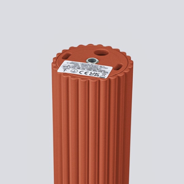 Orangefarbene Sockelleuchte mit gerippter Oberfläche