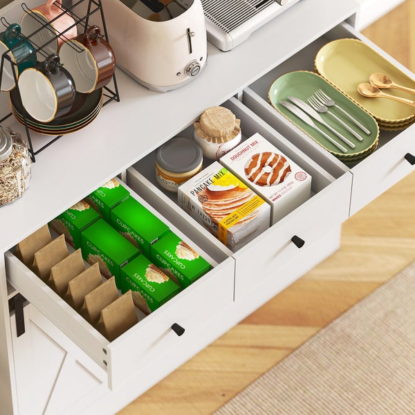 Organisierter weißer Küchenschrank mit offenen Schubladen für Backmischungen, Gläser und Geschirr. Toaster und Tassenständer stehen auf der Ablage.