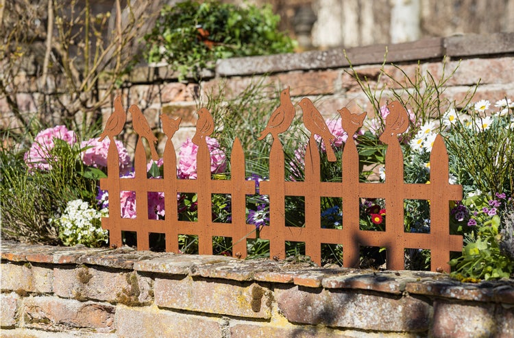 Dekorative Metallzaun-Gartenstecker mit Vogelmotiven in einem Blumenbeet