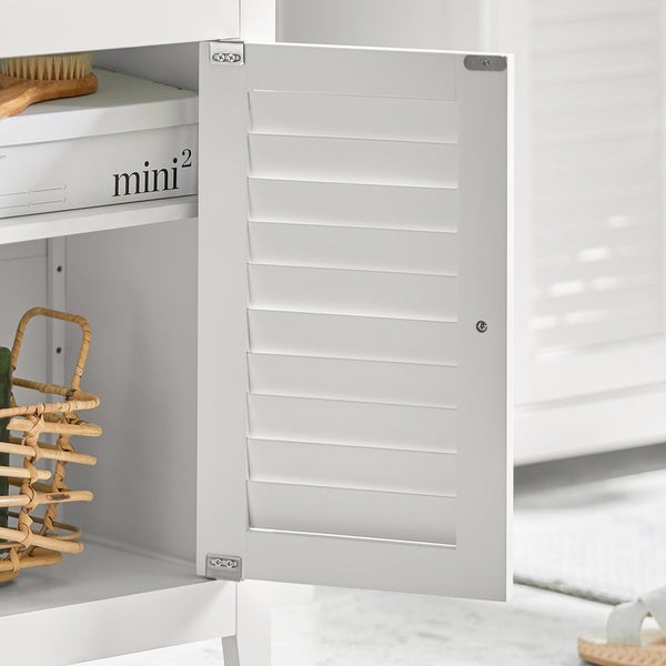 Detailansicht eines weißen Badezimmerschranks mit Lamellentür und Innenraum mit Korb und Aufbewahrungsbox