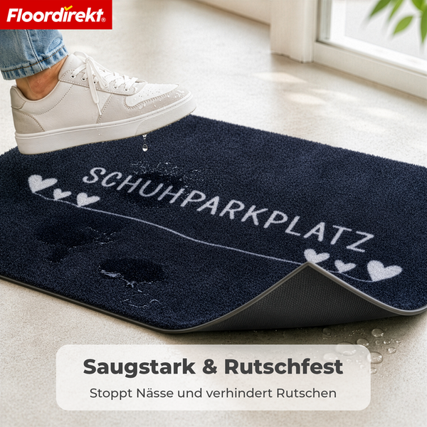 Floordirekt Logo, saugstarke und rutschfeste Fußmatte mit Schriftzug Schuhparkplatz und Herzmotiven in einer Wohnumgebung.