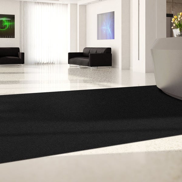 Schwarze Eingangsmatte in einem modernen Wartebereich.