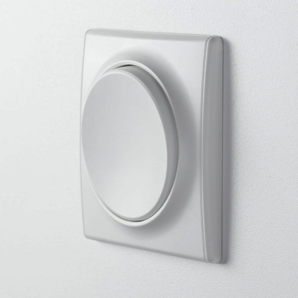 Ein runder Unterputz Drehdimmer mit quadratischem Rahmen montiert an einer Wand