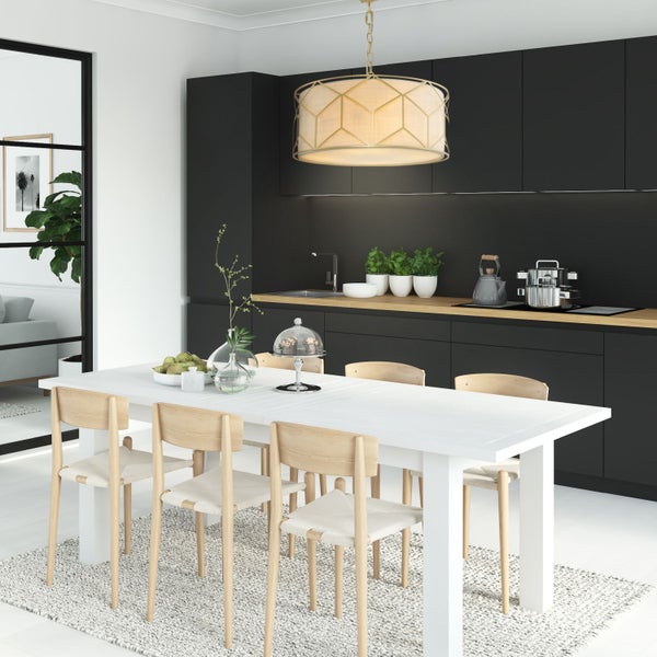 Esszimmer mit Esstisch, Stühlen und Küchenzeile im Hintergrund.