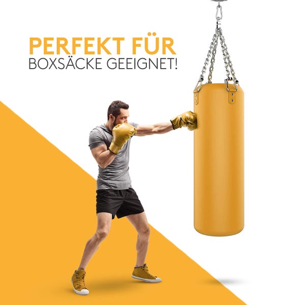 Ein Mann beim Training an einem Boxsack, der an einer stabilen Deckenhalterung mit Ketten befestigt ist.