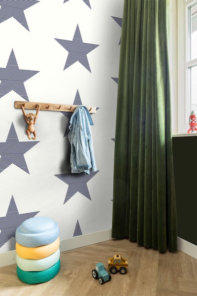 Ein Kinderzimmer mit einer Wand mit Sternentapete, einer Garderobe, einem Stapelhocker und Spielzeugautos.