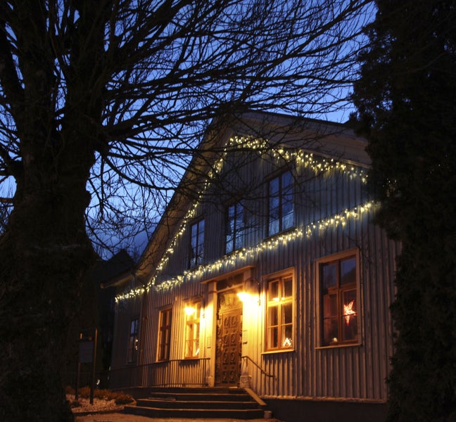 Hausfassade mit Weihnachtsbeleuchtung und Stern im Fenster