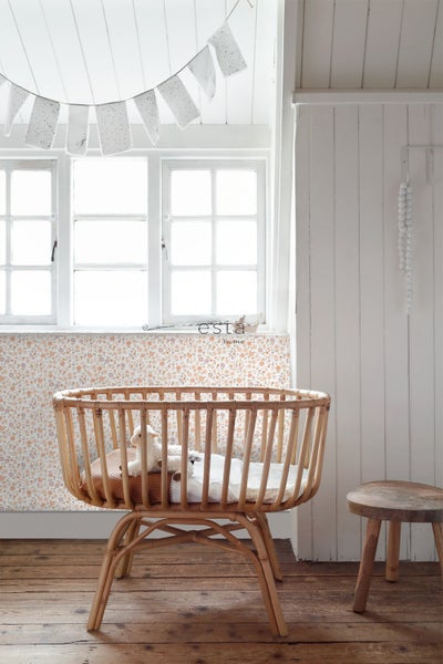 Babyzimmer mit Fenster, Rattanwiege und Holzstuhl
