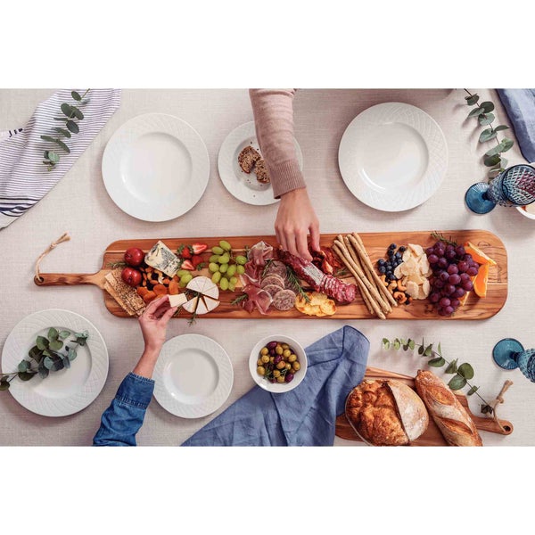 Tisch gedeckt mit Käse, Wurst, Obst, Brot und Tellern für eine gesellige Runde