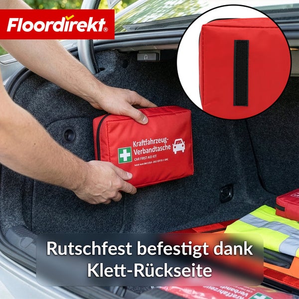 Floordirekt Logo. Kraftfahrzeug-Verbandtasche wird dank Klett-Rückseite rutschfest an der Kofferraumwand befestigt.