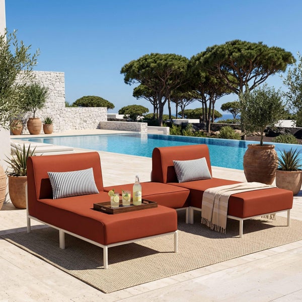 Moderne Outdoor-Lounge-Möbel mit zwei terrakottafarbenen gepolsterten Liegen auf weißem Metallgestell, auf einer hellen Poolterrasse platziert.