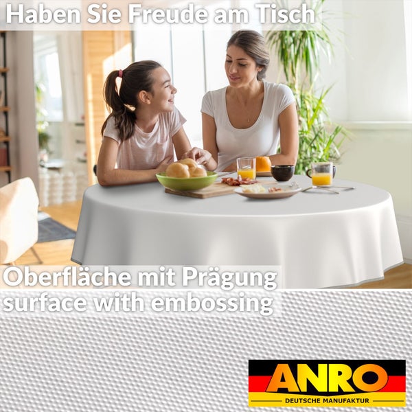 Familie sitzt an einem Esstisch mit einer weißen Tischdecke von ANRO