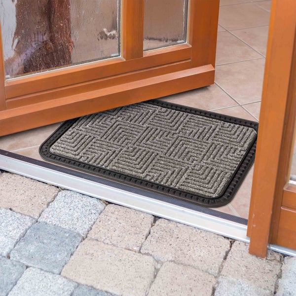 Fußmatte mit geometrischem Muster vor einer geöffneten Tür