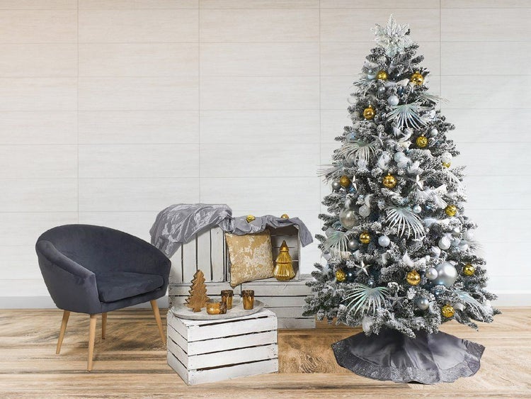 Weihnachtliche Raumszene mit dekoriertem Weihnachtsbaum, Sessel und weißen Holzkisten als Dekorationselement.